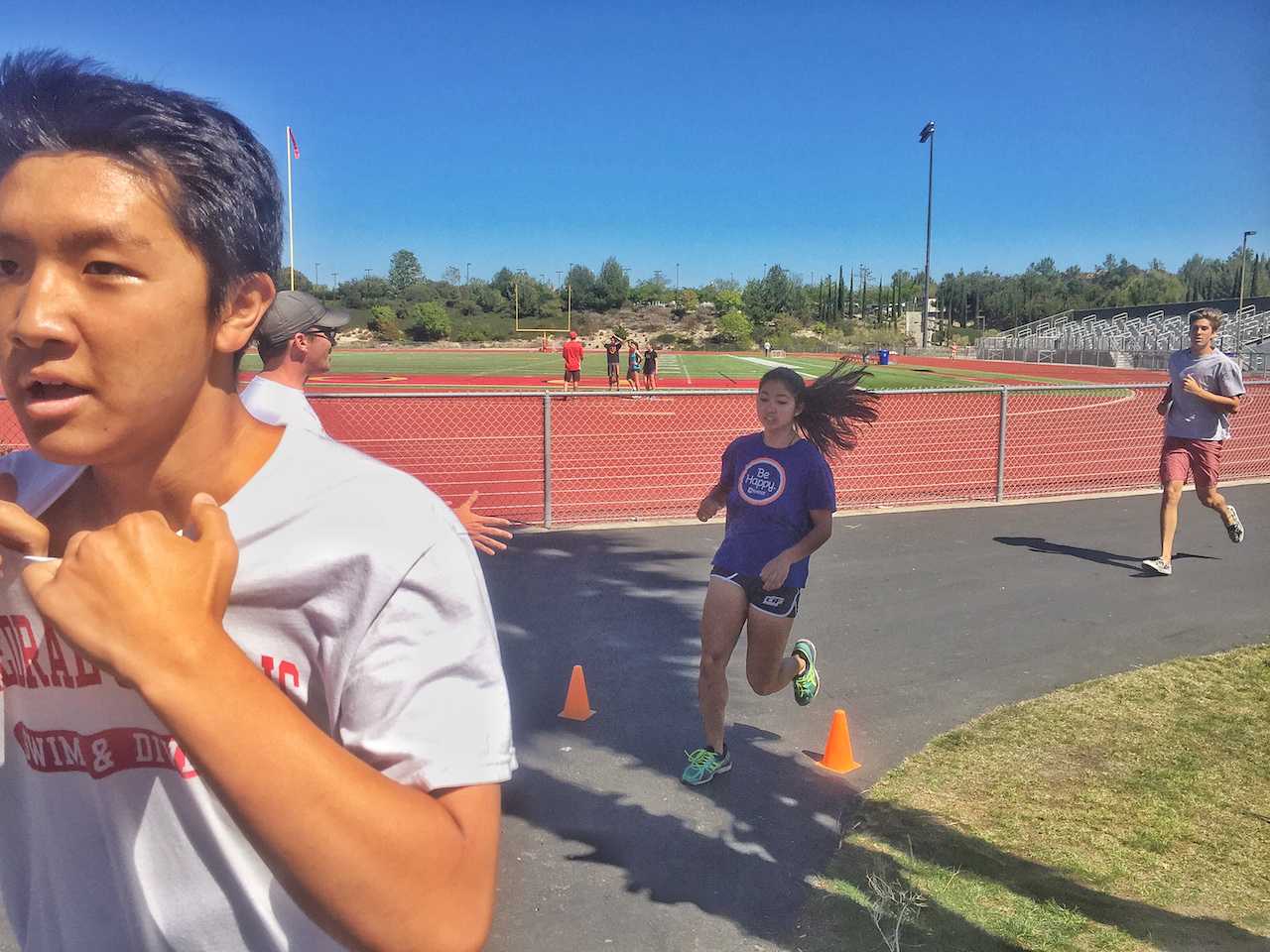Young Han '18 prepares to dive into the swimming portion of the swim and track meet while Claire Hobrock '16 crosses the finish line to the running portion and Dennis Blyashov '17 trails behind.