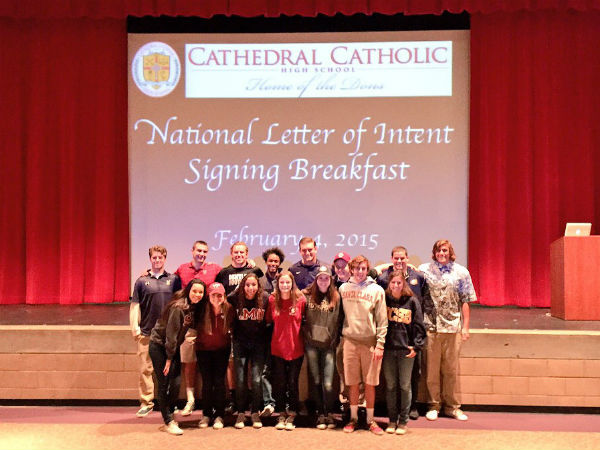 Seventeen seniors pose in front of the signing table. The students signed for sports ranging from football to sand volleyball.