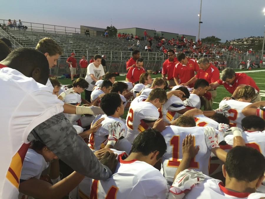 Varsity football players pray before Helix game. Photo by: Mr. Dan Grazier 