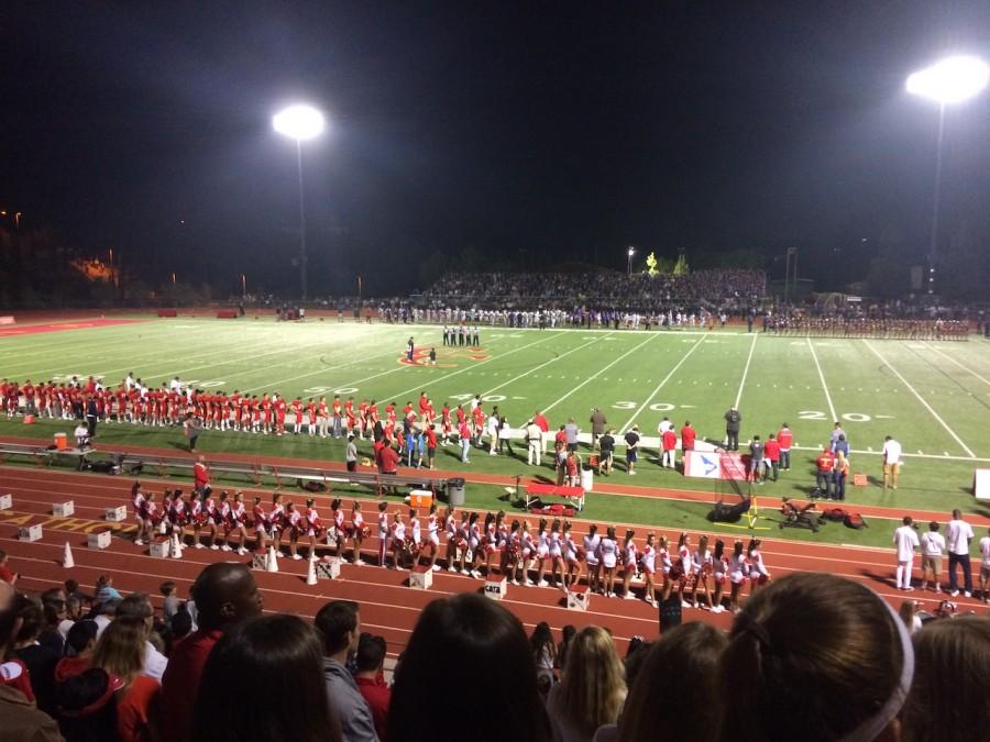 Cheer and football teams line up for the national anthem at the Holy Bowl, Friday Oct. 23, 2015. 