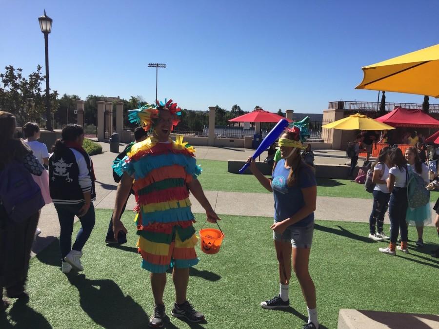 Mr. Owen and Mrs. Ellis dress up as piñata and blind-folded piñata partaker for Halloween.