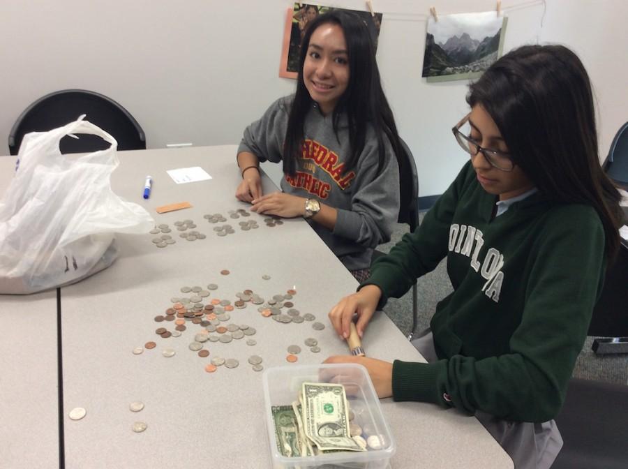 Pia Asuncion ’16 and Eliza Lozano ’16 sort and count money for the holiday drive, benefitting Toussaint Academy in San Diego. 