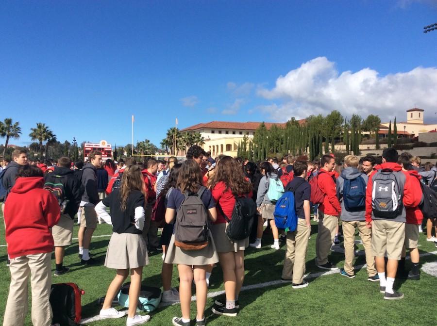 Students wait in line on the field during the emergency drill. 