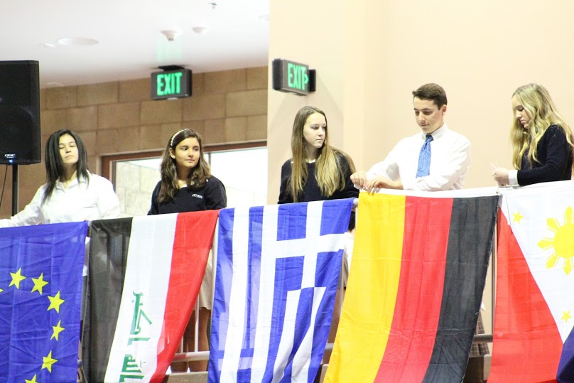 Campus Ministers Ela Chavez 17, Sofia Palomas 17, Natalie Rotherham 17, Chad Dea 17, and Katie Van Deventer 17 (pictured from left to right) display flags on the railings of the Claver Center.