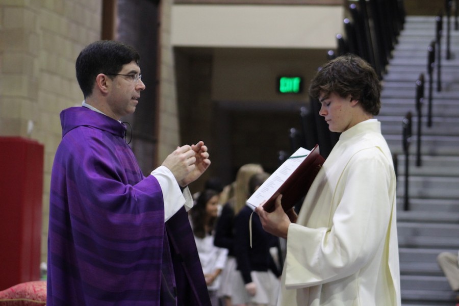 Father Wainwright, joined by JD Carney ’17, blesses the CCHS students, faculty and parents who attended mass together on Wednesday. 