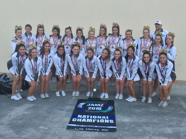The Cathedral Catholic High School cheer team poses with its National Championship banner at the Jamz National Competition in Las Vegas, NV. This is the first time the cheer team has placed first at a national competition, and its banner is now displayed inside the Claver Center gym.  