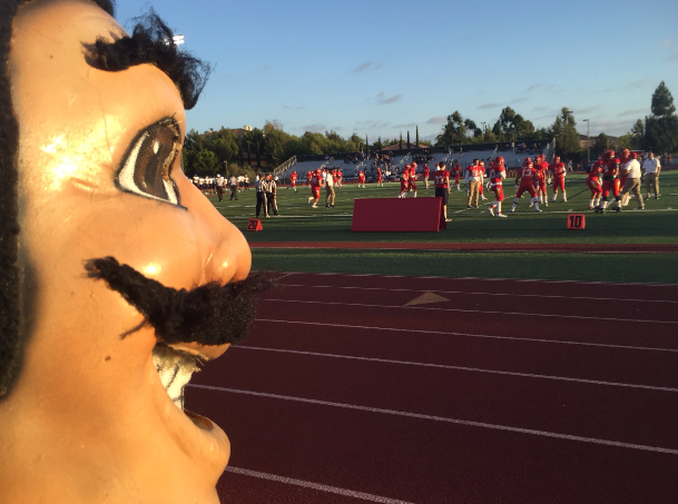 The CCHS varsity football team practices before the Friday night lights

kickoff while the Don watches in the foreground.