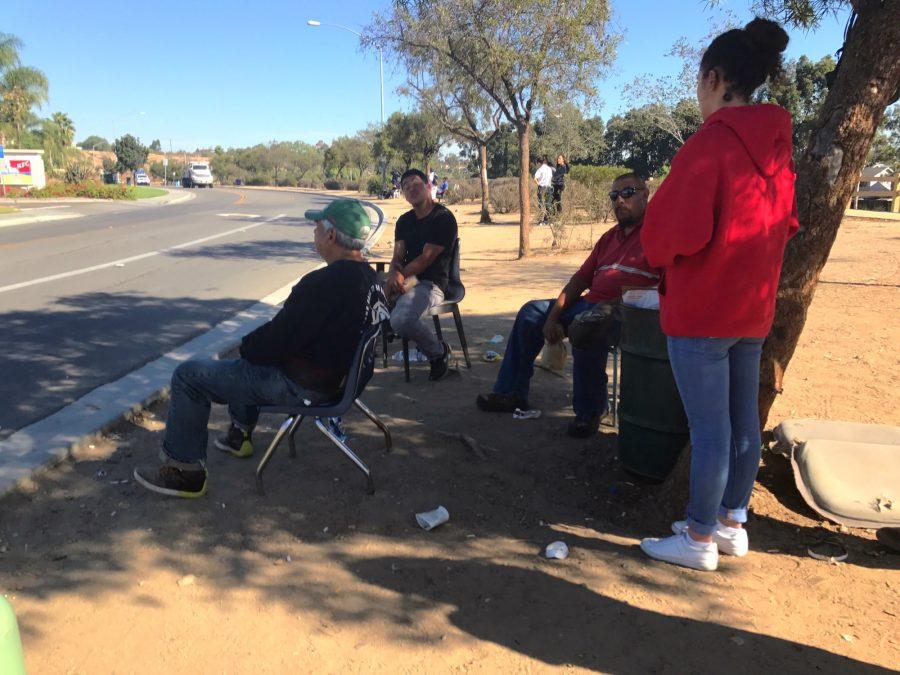 Isabel Valencia 17 converses in Spanish with a day laborer outside a San Diego Home Depot while on a campus ministry service trip.