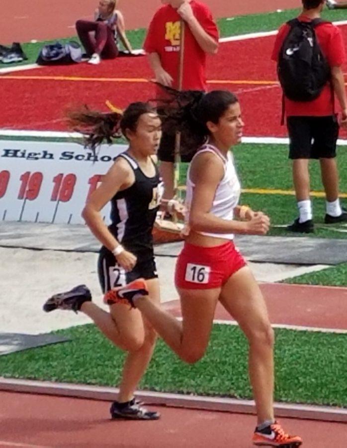 Competing in the 800 meter race, Cathedral Catholic High School distance runner Dani Lopez 17 passes an Arcadia High School runner while running down the backstretch of the second lap.