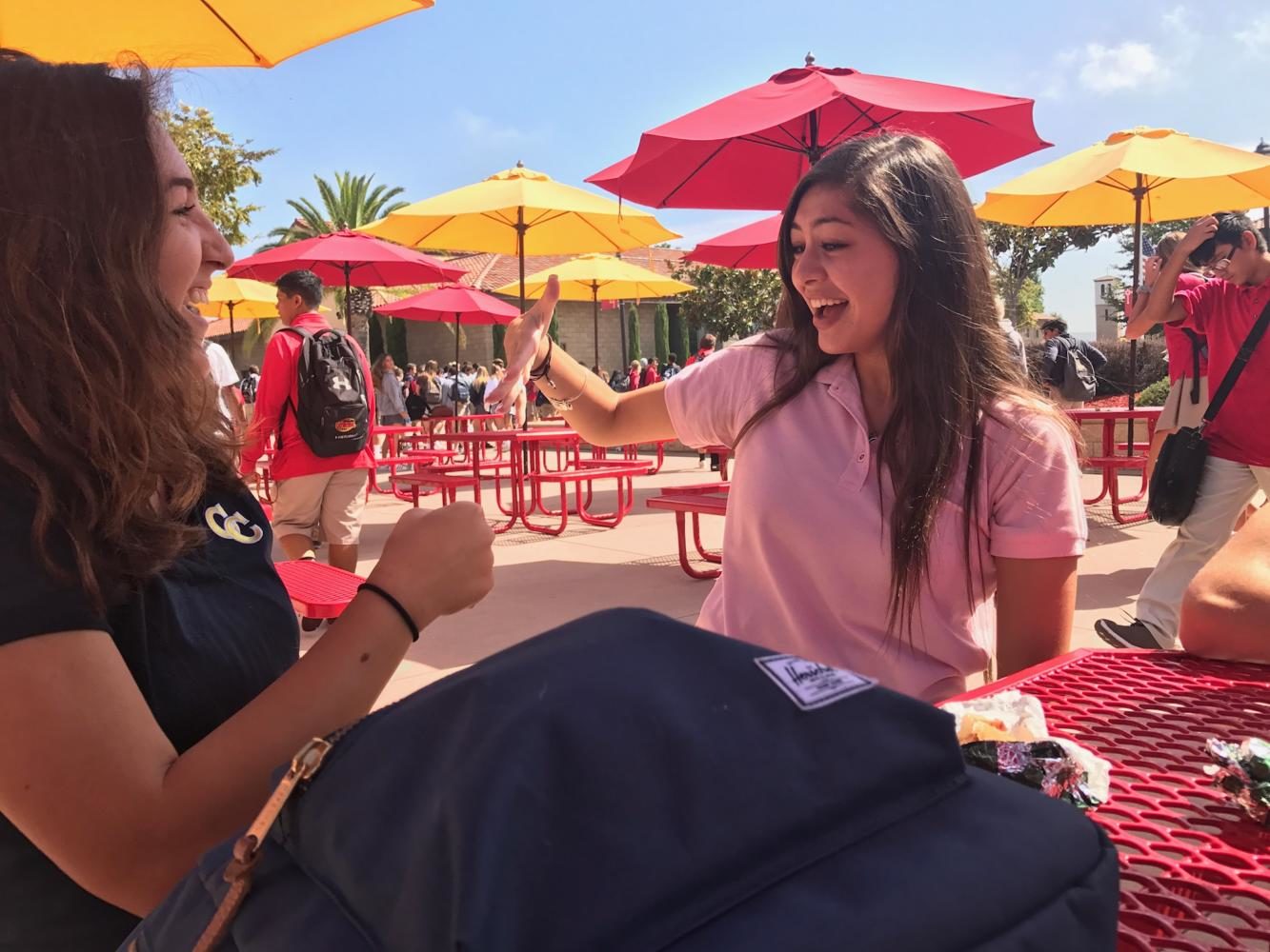Halle Way 19 and Carly Duenas 19 share laughs and high fives on Thursday at lunchtime on. Photo by Riley Hetherington