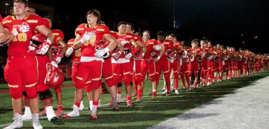 Hand over heart, members of CCHS football team stand together, showing respect for the flag before taking the field at a recent contest.
