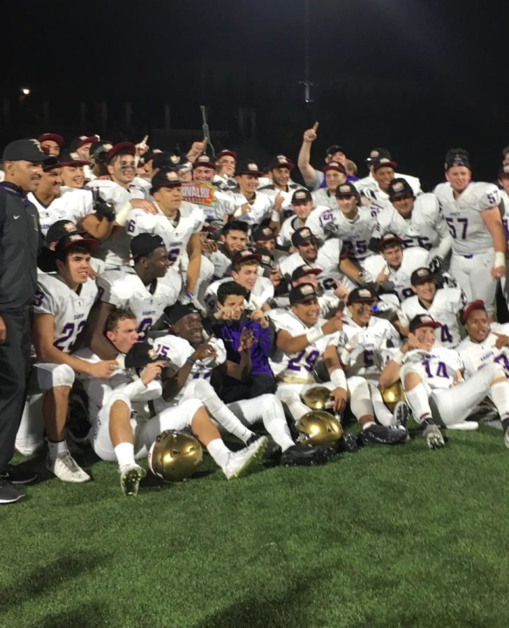 Members of the SAHS football team celebrate their 45-6 victory over CCHS with a team photo while hoisting the Holy Bowl trophy.