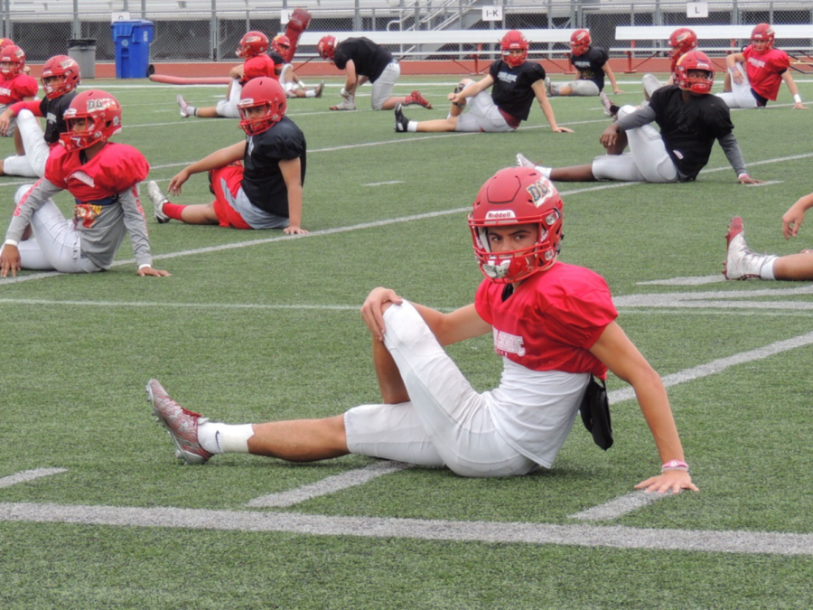 Zion Sorani 19 stretches out with his team before practice in preparation to play his best against Saint Augustine High School in the long-awaited Holy Bowl. 