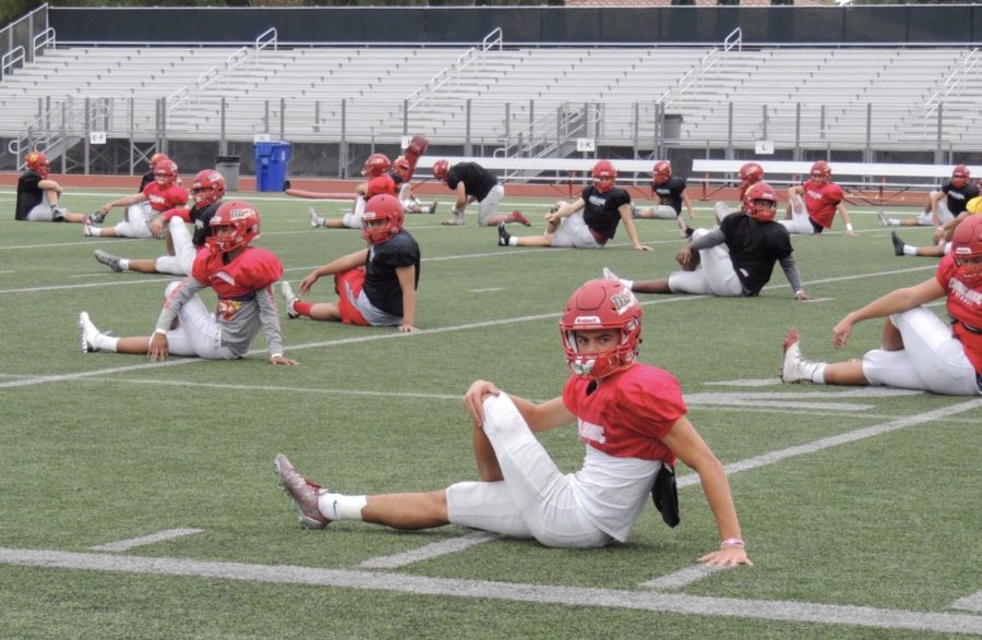 Zion Sorani 19 stretches out with his team before practice in preparation to play his best against Saint Augustine High School in the long-awaited Holy Bowl.