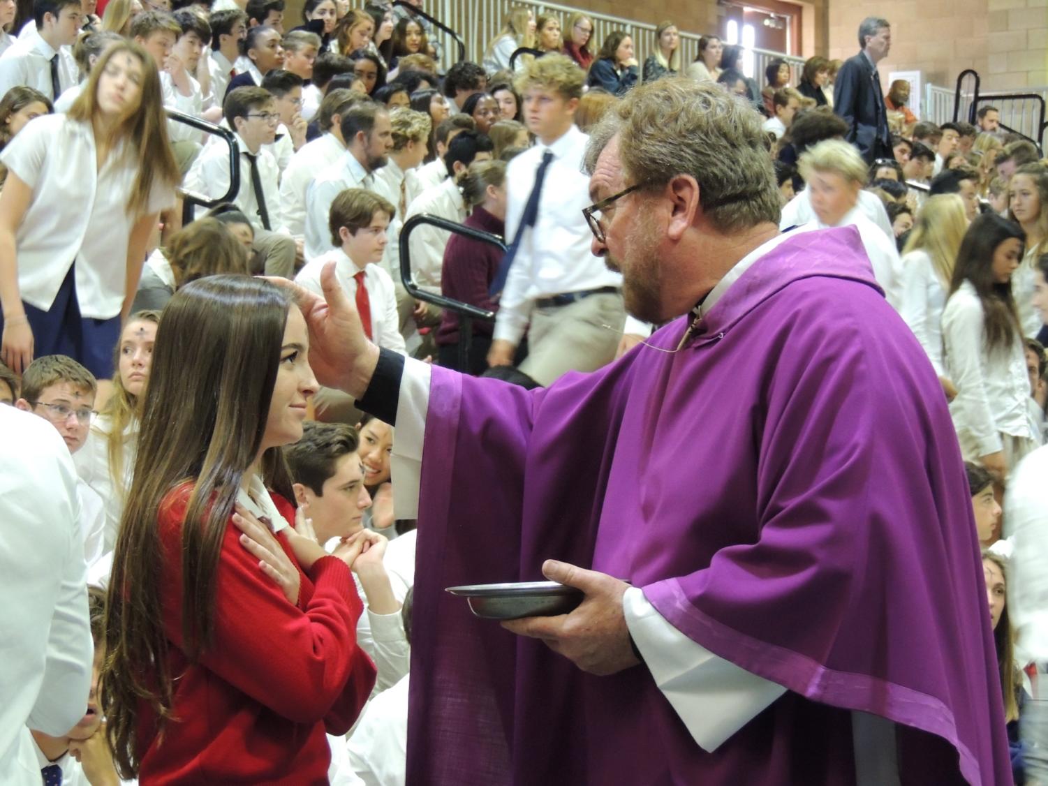Fr. Michael White anoints a CCHS student with ashes during Ash Wednesday Mass.