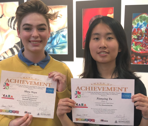 CCHS students Cat Noya ‘18 and Bonnie Yu ‘18 (left to right) pose at Liberty Station in Point Loma with their honorable mention certificates for the “9-12 Two Dimensional Art” category at the 2018 Youth Art Month.