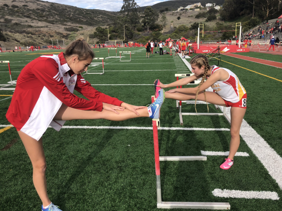 CCHS hurdlers Nikki Mullin 19 and Kenzie Kuras 19 stretch in preparation for their 100m hurdles race Thursday against competitors from Valley Center High School and Mt. Carmel High School.