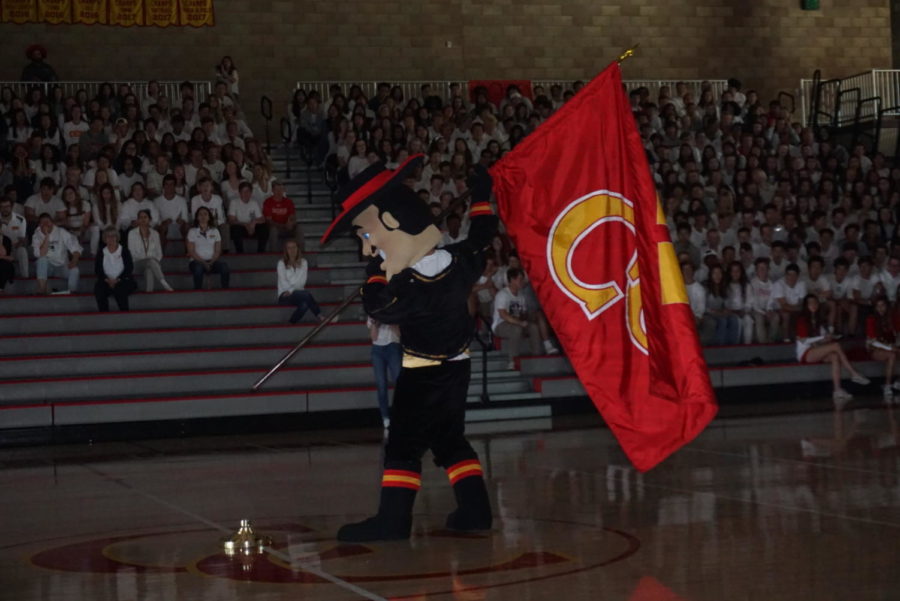 The Don, the CCHS mascot, anticipates  setting the CCHS flag in a flag stand as CCHS students watch intently at the Spring Sports Rally Friday.