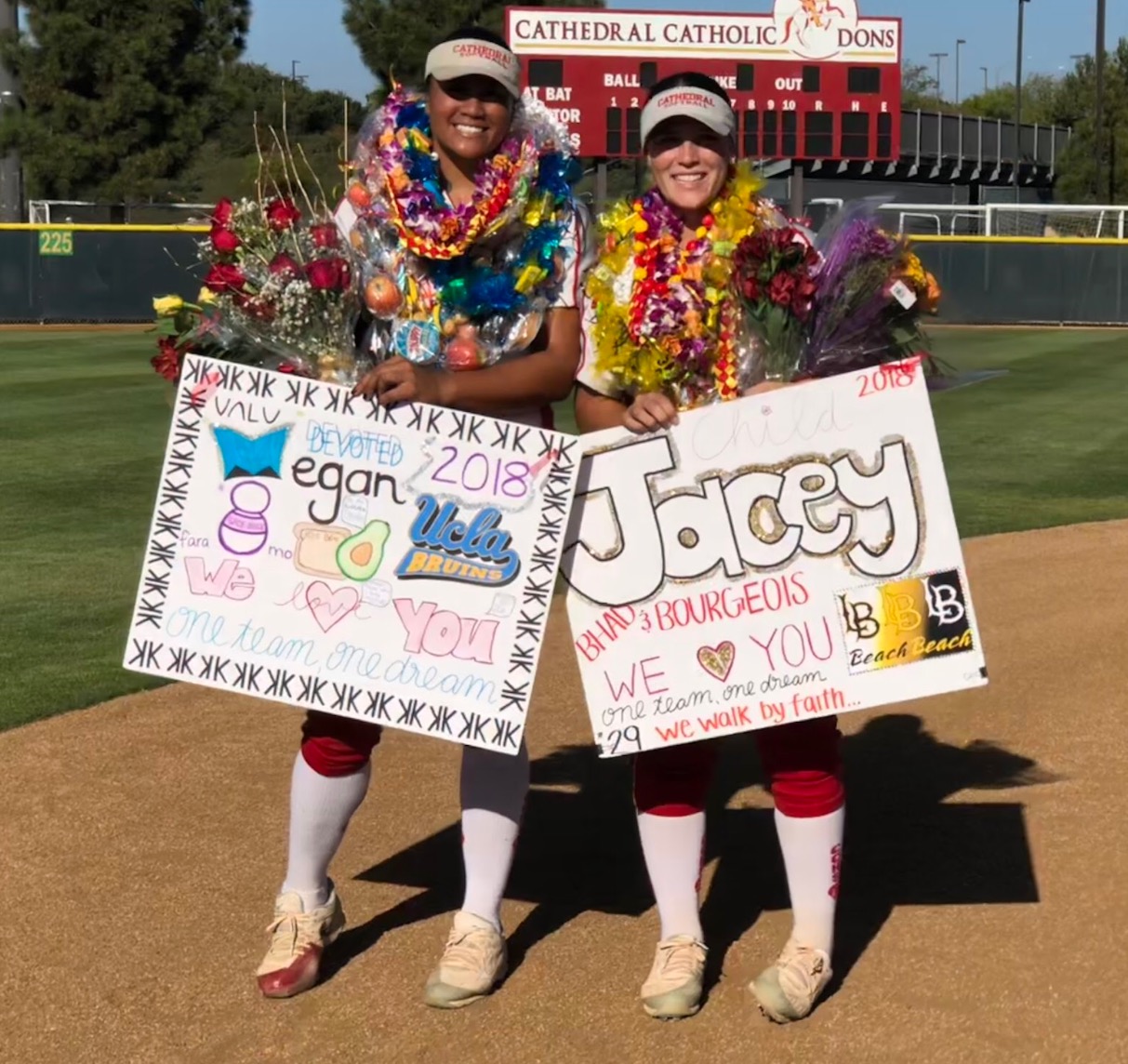 CCHS varsity softball players Megan Faraimo '18 and Jacey Bourgeois '18 sport the leis, flowers, and posters given to them on senior night Wednesday after the team beat University City High School 11-0.