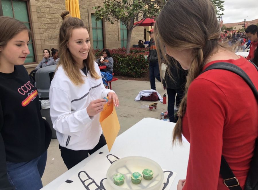Riley Staal 19 buys a cupcake from co-leader of the American Sign Language club Emmy Henson 19 at the ASB Spring Carnival Friday. The proceeds the ASL club made at this event will go towards getting the club new sweatshirts. 