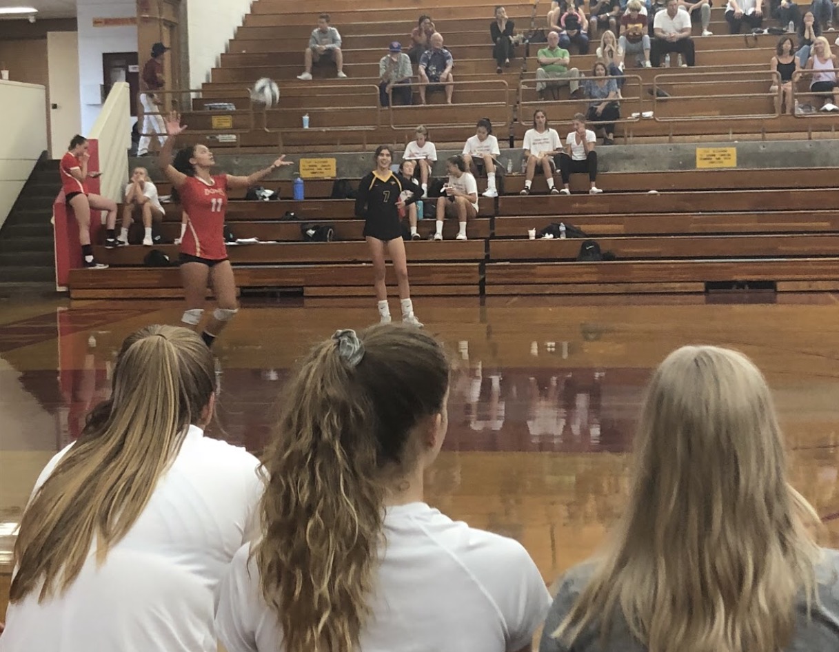 Teammates watch as girls varsity volleyball player Kira Smith ‘21 serves the ball at Torrey Pines High School last Thursday.