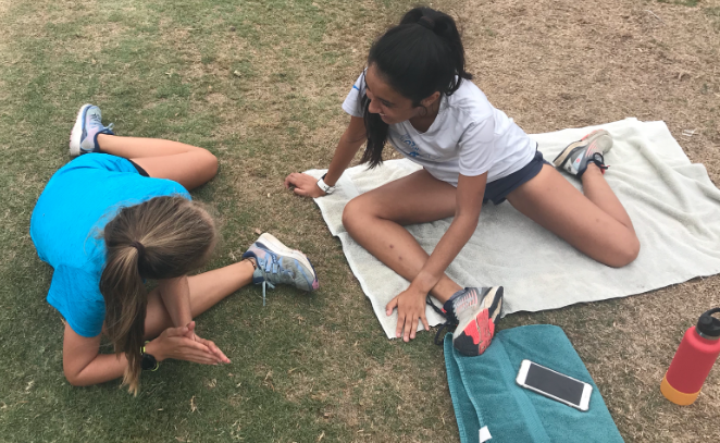 Natasha Preece ‘21 and Maxine Arambulo ‘20, members of the Cathedral Catholic High School cross country team, stretch after a long run in preparation for the upcoming meet on Saturday. 
