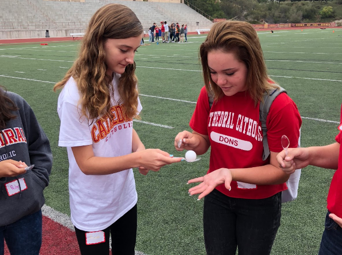 Anna Fazio 22’ and Sophia Faucett 22’ participate in a field game during the reinvented freshmen retreat that focuses on introducing the freshmen to their faith and building a community.
