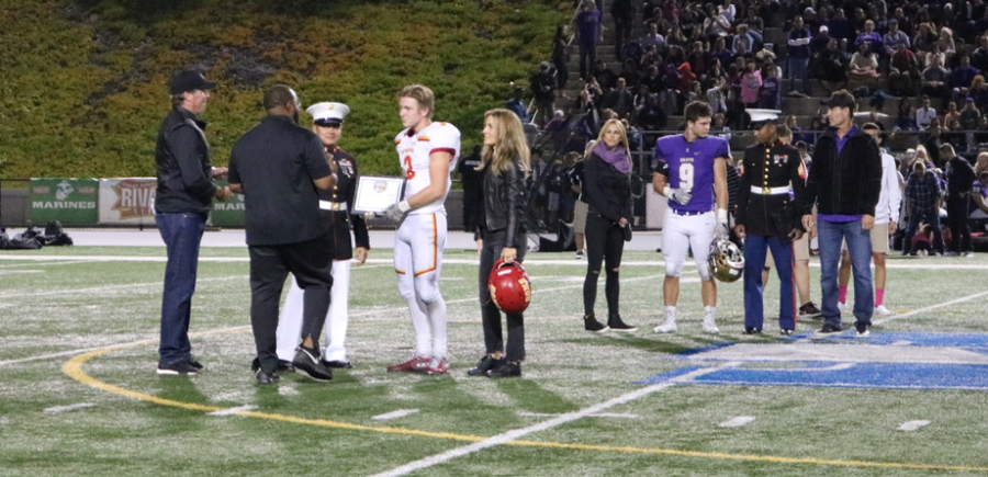 Oliver Mirer 19 receives athletic recognition from the American Rivalry Series during the halftime ceremony at Friday nights Holy Bowl, where the Dons beat the Saints 34-14. 