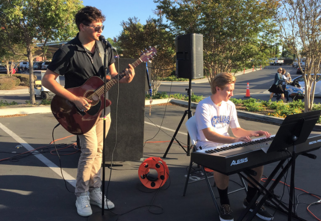 During the annual Trunk or Treat event Thursday, Sergio Vinas ‘20 (left) and Philip Krol ‘19 entertain the middle and elementary school children and their guardians with music as they take part in Halloween activities.
