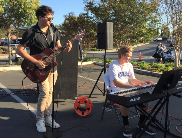 During the annual Trunk or Treat event at Cathedral Catholic High School, Sergio Vinas ‘20, left, and Philip Krol ‘19, right, entertain the middle and elementary school children and their guardians with music as they take part in Halloween activities.