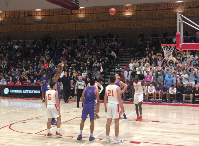Dillon Wilhite ‘21 (right), Alex Dennis ‘20 (center), and Scotty Prunty ‘20 (left) watch as Chibuzo Agbo ‘20 of Saint Augustine High School makes a free throw at the “Holy War” on Thursday night. SAHS ultimately won the game, a long-standing tradition between Cathedral Catholic High School and Saint Augustine High School.
