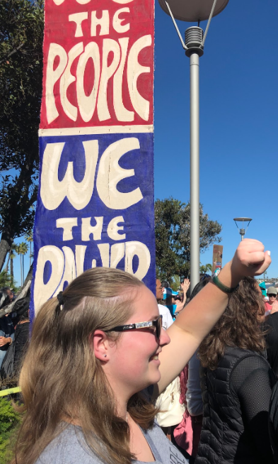 Emma McIntosh ‘21 raises her fist in cheer and agreement Saturday as she listens to opening speeches at the third annual San Diego Women’s March. McIntosh sports a “The future is female” shirt in the spirit of activism for women’s rights. 
