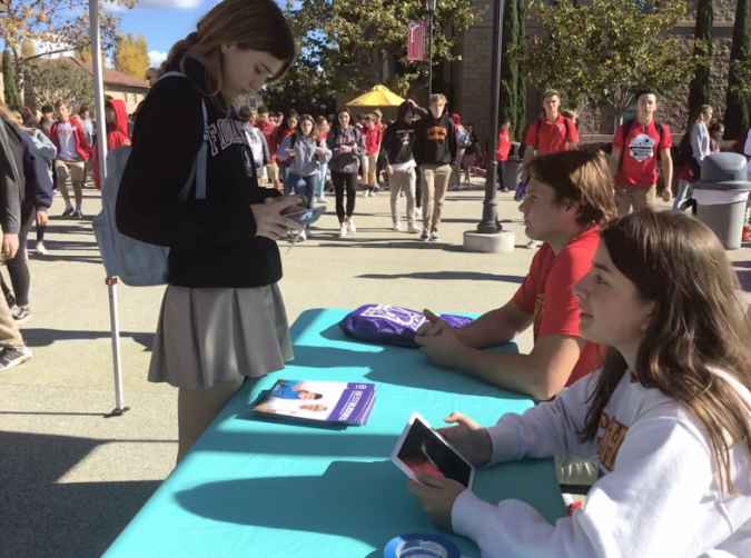 Morgan Yacullo ‘20 (left) signs up for Best Buddies during lunch at a booth run by president Holden Brosnan ‘20 (middle) and events coordinator Alicia Morales ‘19 (right).

