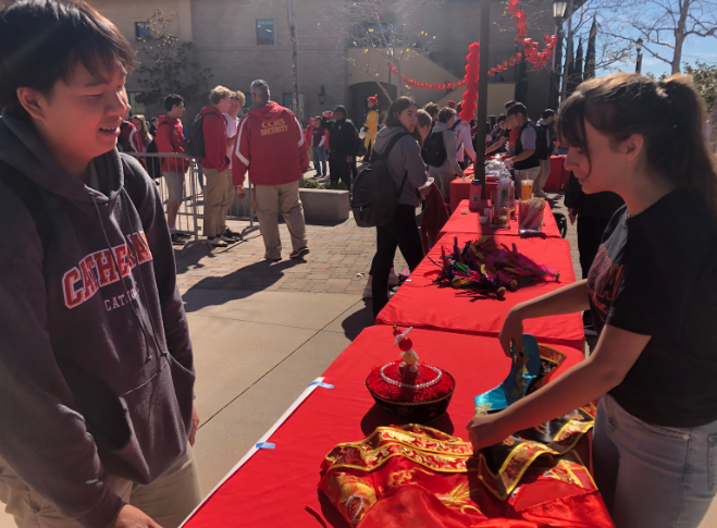 Charlotte Schmitt ‘21 and Kyle Wong ‘21 look at the traditional Chinese decorations set out for Cathedral Catholic High School’s celebration of Chinese New Year on Friday. The festivities, which celebrated the Year of the Pig, included food and traditional dragon dances. 
