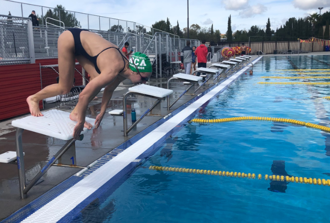 As teammates prepare the pool for their first intersquad meet, Catie Pentlarge ‘20 practices her start for the Red and Gold meet, an unofficial tryout for the varsity swim meet where swimmers compete in 50 yards of all four strokes, to transition from club to high school season.