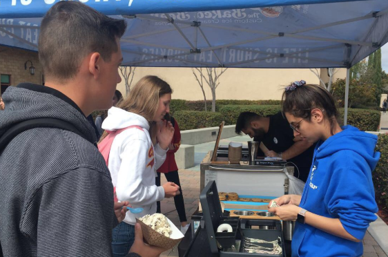 Kellen Lary ‘22 waits to receive his change as Caryn Telfer ‘22 orders ice cream from a Baked Bear stand at school. As a part of Friday’s final Life Week day, with the theme of Celebrate Life!, students bought ice cream and ice cream sandwiches at lunch.