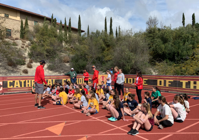 Catholic elementary and middle school students  listen to Mr. Dan Geiger, the Cathedral Catholic High School track and field head coach, at the annual Catholic School Meet hosted by CCHS. CCHS track athletes and coaches organize the meet, which include Saint Michael’s, Notre Dame Academy and Saint James Academy. 
