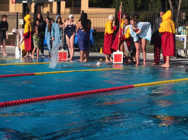 Jia Budelsky ‘22 and Tally Gruwell ‘22 cheer on and count for teammate Jilly Roberts ‘20 as she swims the final lap of the 500- yard freestyle event at the meet against Our Lady of Peace and Saint Augustine High School on Friday. 
