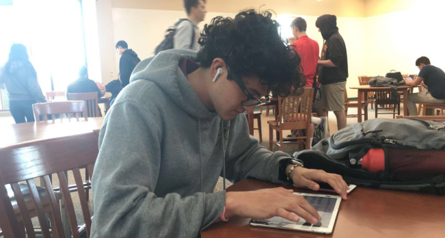 Alex Cruz ‘19, who stays at CCHS after school waiting for the school bus to take him home, works on his homework last Friday afternoon. 