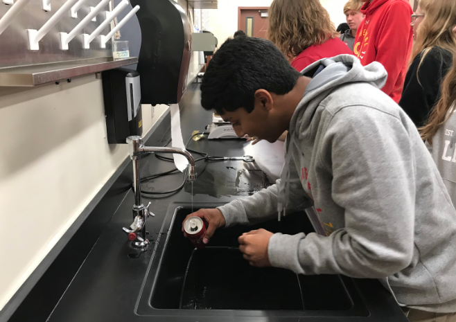 Preparing for an activity in his chemistry class, Ryan Oliveira ‘21 fills the soda can he brought to class in anticipation of the class’s activity, a teacher-run demonstration of real life application of the ideal gas laws.



