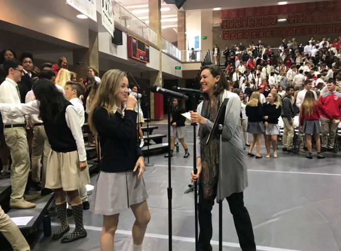 As CCHS students shake hands and exchange peace, Mikaela Adams ‘19 and CCHS music teacher Miss Jessica Swift laugh while preparing for the upcoming song “Take me to the King” during Thursday’s liturgy celebration.

