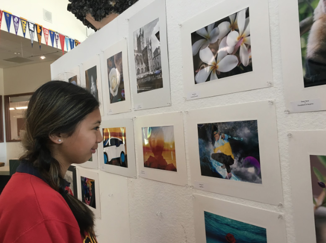 Carrie Samonte ‘21 admires the artwork up for the Visual and Performing Arts Showcase in the library on Friday after school. The VAPA showcase features a collection of ceramics, photography, and various other visual arts. 
