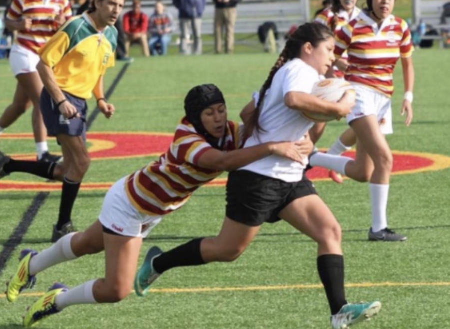 CCHS varsity girls rugby team player Kaelene Walter ‘19 attempts to stop the opposing team’s ball carrier in a home match. 