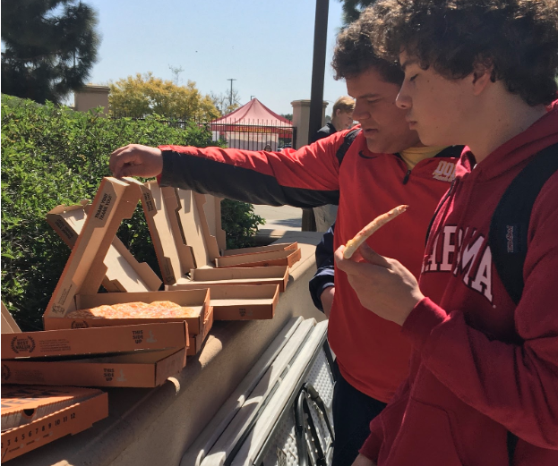 Students grab slices of pizza in front of St. Therese Chapel Friday. Members of St. Therese of Carmel Youth Ministry, who provide the food, can be found on the chapel steps every Friday at lunch, where any CCHS student is welcome to talk and eat. 