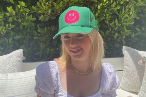 Sophie Galluccio, the owner of Glitter + Sand, is modeling her bestselling hat. Sophie also sells other unique products that showcases her style.
