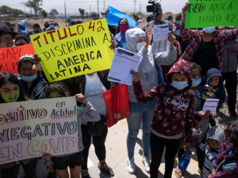 Immigrants protest against Title 42 along the U.S. southern border. The signs claim the Act discriminates agains Latin Americans.